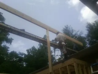 Carpenter setting a ridge beam over a new addition frame — Ice Dam Removal by Roofing Brothers in Connelly Springs
