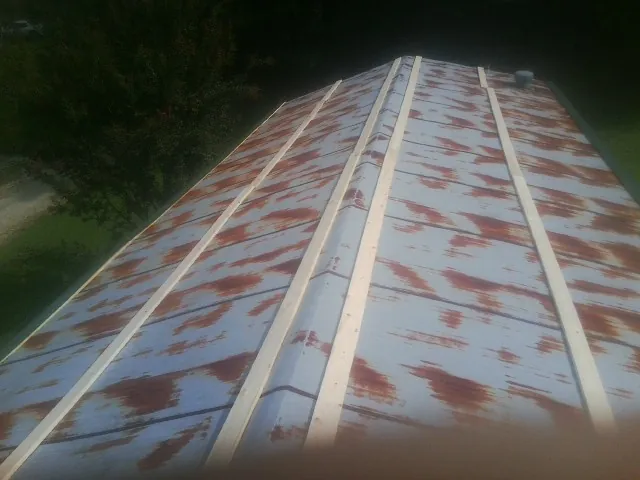 Rusted metal roof panels with new wood purlins before replacement — Storm Damage Roof Repair in Connelly Springs by Roofing Brothers