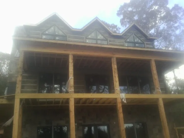 Dormers and porch framing on a large log home under construction — Roof Coating work by our crew in Connelly Springs